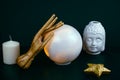 still life with a crystal ball and wooden hand, Buddha head ceramic statuette and white candle on a black background