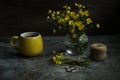 Still life with cup of coffe and yellow flowers