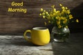 Still life with cup of coffe and yellow flowers and text