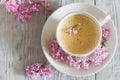 Still life with cup of coffee and spring lilac flower Royalty Free Stock Photo