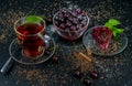 Still life with a Cup of strong tea, ripe cherries and cherry cake on a black background Royalty Free Stock Photo