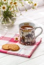 Still life with a cup of tea, cookies and daisies