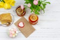 Still life with cups of tea, pieces of cake, bouquet of pink flowers in a pink pot, marshmallow and heart-shaped candle on a white Royalty Free Stock Photo