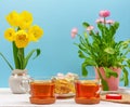 Still life with cups of tea, pieces of cake, bouquet of pink flowers in a pink pot, marshmallow and heart-shaped candle and yellow Royalty Free Stock Photo