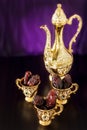 Still life with dates with golden Traditional Arabic coffee set with dallah and mini cup. Dark background. Royalty Free Stock Photo