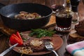 still life of delicious hot freshly cooked marbled beef steak in frying pan and on clay plate Royalty Free Stock Photo