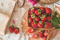 Still life details in home interior of living room. Basket with strawberries Pions flowers and spring decor on the books Royalty Free Stock Photo