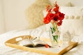 Still life details in home interior of living room. Open book and vase red tulips. Read and rest. Royalty Free Stock Photo