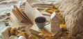 Still life details in home interior of living room. Sweaters and cup of tea with a candle house and autumn decor on the books