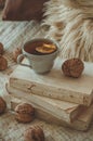 Still life in home interior of living room. Sweaters and cup of tea with a cone on the books. Read. Cozy autumn winter concept Royalty Free Stock Photo
