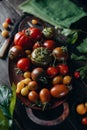Still life, different varieties of tomato scattered on a wooden table, soft morning light, top view Royalty Free Stock Photo