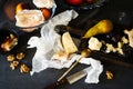 Still life on dinner table with cheese, pear, wine, walnut, pomelo on wooden board Royalty Free Stock Photo