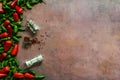 A still life with a dirty pink surface with lots of green and red peppers with red pepper pot and perspex grinders with salt and Royalty Free Stock Photo