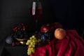 Still life in the Dutch style. Blurred image of fruits and a glass of wine on a dark background Royalty Free Stock Photo