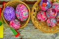 Still life with Easter eggs. Decorated Easter eggs lay in a wicker basket on a white wooden background, top view. Easter Royalty Free Stock Photo