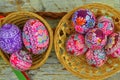 Still life with Easter eggs. Decorated Easter eggs lay in a wicker basket on a white wooden background, top view. Easter Royalty Free Stock Photo