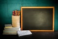 Still life of empty blackboard and colorful pencils with books o Royalty Free Stock Photo