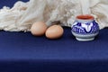 Still life with eramics pot, two eggs and textile with lace. Royalty Free Stock Photo