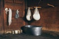 Still life with farmer cheese draining in cheesecloth above buckets on rustic wooden background