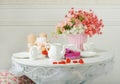 Still-life with flowers, cups and kettle on white table Royalty Free Stock Photo