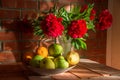 Still life with flowers and fruit against a brick wall Royalty Free Stock Photo