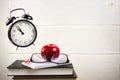 Still life with flying alarm clock, books, notebook and red apple Royalty Free Stock Photo