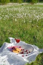 Still life and food photo. Cherry and waffle berries lie on a wicker round napkin and crumpled fabric