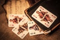 a still life of four playing cards on burlap and a beautiful still life with old books and a clock Royalty Free Stock Photo