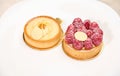 Still life with French baked tartlet with lemon meringue and partial view of raspberry cake, isolated white