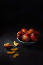 Still life of fresh nectarines with droplets of water in a bowl on dark background. Low key. Royalty Free Stock Photo