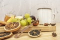 Still life with fresh fruits and slices of dried citrus and sweet condiments next to a cup of tea Royalty Free Stock Photo