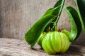 Still life with fresh garcinia cambogia on wooden background