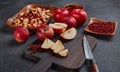 Still life with fresh lingonberries, red appples with knife on black cutting board and homemade jam on dark background. Top view Royalty Free Stock Photo