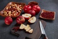 Still life with fresh lingonberries, red appples with knife on black cutting board and homemade jam on dark background. Top view Royalty Free Stock Photo