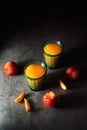 Still life of fresh nectarines with droplets of water and juice in turquoise vintage glasses on dark background. Low key Royalty Free Stock Photo