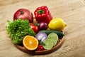 Still life of fresh organic vegetables on wooden plate over wooden background, selective focus, close-up Royalty Free Stock Photo