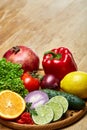 Still life of fresh organic vegetables on wooden plate over wooden background, selective focus, close-up Royalty Free Stock Photo