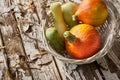 Still life with freshly collected vegetables in a wicker backet on the old wooden boards