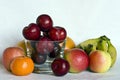 A still life of mixed fruit around and in a small glass bowl. Royalty Free Stock Photo