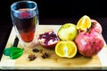Still life of fruit. The garnet is cut on the Board. The orange is cut on a kitchen board. A glass of pomegranate juice