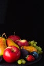 Still life of fruits, apples, pears, grapes, figs, strawberries and plums on a black background Royalty Free Stock Photo