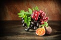 Still life with fruits: grape, fig in the antique copper tin cup Royalty Free Stock Photo