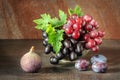 Still life with fruits: grape, fig, plum in the antique copper tin cup Royalty Free Stock Photo