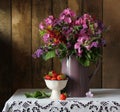 Still life with garden flowers in jug and ripe strawberries Royalty Free Stock Photo