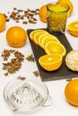 A still life with glass juicer, sliced oranges, cut glass vase filled with fresh orange juice surrounded by slices and whole Royalty Free Stock Photo