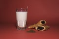 Still life of glass of milk with chocolate pie- red background