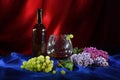 Still life with glass of red wine, bunch of grapes and lilac Royalty Free Stock Photo