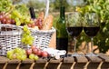 Still life with glass of red wine grapes and picnic basket on table Royalty Free Stock Photo