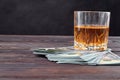 Still life glass of whiskey and dollars. Royalty Free Stock Photo