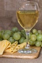 Still life with glass of white wine, cheese and grapes Royalty Free Stock Photo